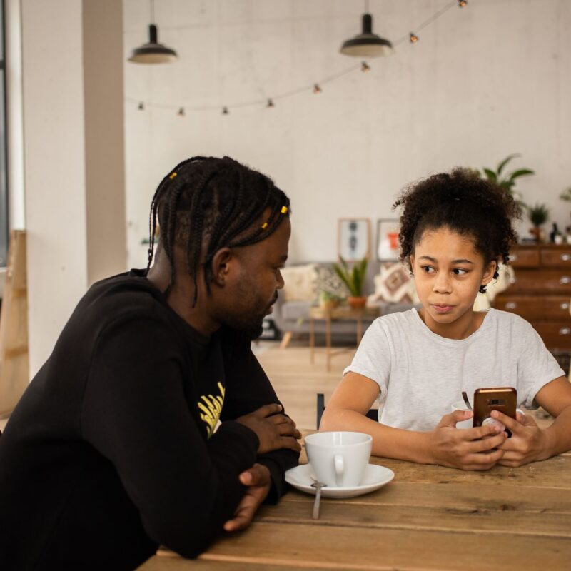 A father and daughter looking at a smartphone together