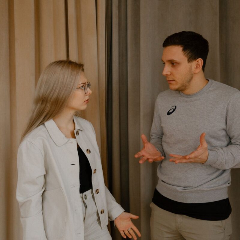 A young couple having an emotional argument indoors