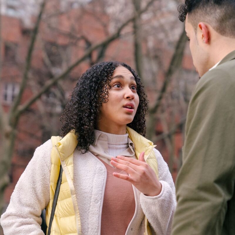 A couple arguing outdoors during the daytime